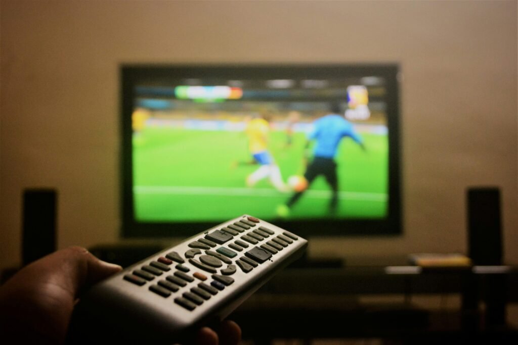 A football fan watching a match at home, reflecting the online engagement of Reddit LFC in 2025