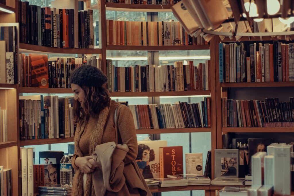 Shopper browsing books in a cosy UK bookstore with wooden shelves and warm lighting, reflecting a typical WHSmith store atmosphere and UK opening hours.